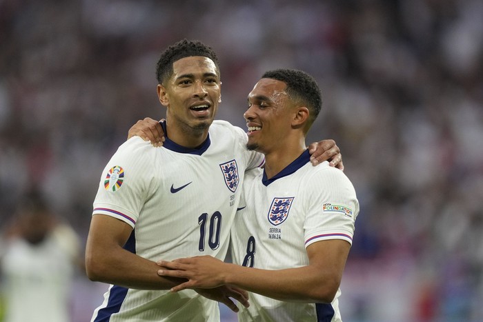 Englands Jude Bellingham, left, celebrates with Englands Trent Alexander-Arnold after scoring the opening goal during a Group C match between Serbia and England at the Euro 2024 soccer tournament in Gelsenkirchen, Germany, Sunday, June 16, 2024. (AP Photo/Martin Meissner)