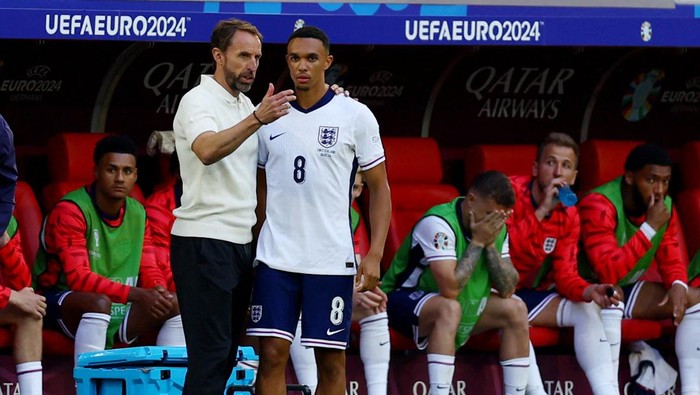 Soccer Football - Euro 2024 - Quarter Final - England v Switzerland - Dusseldorf Arena, Dusseldorf, Germany - July 6, 2024 England manager Gareth Southgate speaks with Trent Alexander-Arnold before he comes on as a substitute REUTERS/Lee Smith