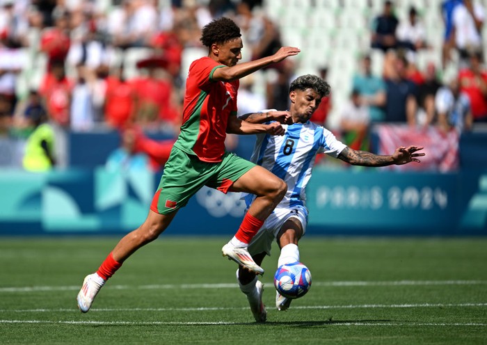 SAINT-ETIENNE, FRANCE - JULY 24: Eliesse Ben Seghir #7 of Team Morocco is challenged by Cristian Medina #8 of Team Argentina during the Mens group B match between Argentina and Morocco during the Olympic Games Paris 2024 at Stade Geoffroy-Guichard on July 24, 2024 in Saint-Etienne, France. (Photo by Tullio M. Puglia/Getty Images)