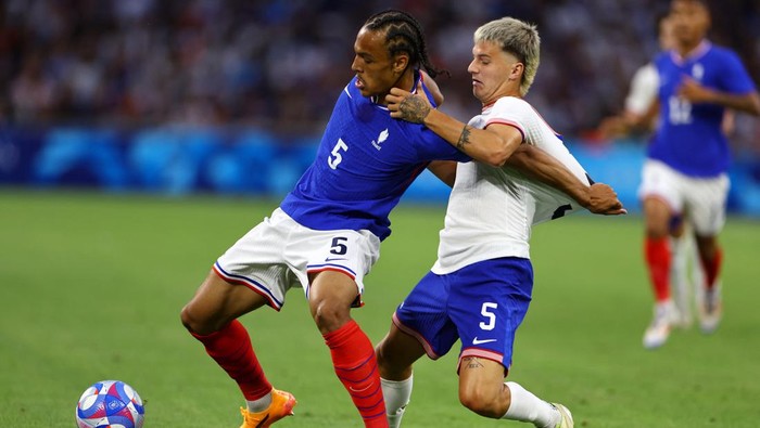 Paris 2024 Olympics - Football - Mens Group A - France vs United States of America - Marseille Stadium, Marseille, France - July 24, 2024. Kiliann Sildillia of France in action with John Tolkin of United States. REUTERS/Luisa Gonzalez