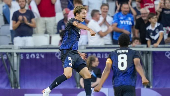 Japans Shota Fujio, left, celebrates scoring his sides 5th goal during the mens Group D soccer match between Japan and Paraguay at the Bordeaux stadium at the 2024 Summer Olympics, Wednesday, July 24, 2024, in Bordeaux, France. (AP Photo/Moises Castillo)