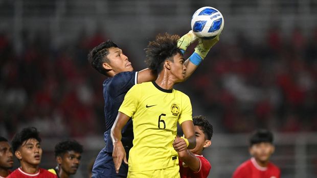 Kiper Timnas Indonesia Ikram Algiffari (kiri) berebut bola dengan pesepak bola Timnas Malaysia Danish Hakimi Bin Sahaludin (kanan) dalam pertandingan semifinal Piala ASEAN U-19 Boys Championship atau AFF U-19 di Stadion Gelora Bung Tomo, Surabaya, Jawa Timur, Sabtu (27/7/2024). ANTARA FOTO/Sigid Kurniawan/tom.