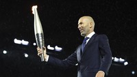 Ini adalah momen sang legenda sepakbola Prancis secara estafet bersiap memberikan api obor Olimpiade yang dibawanya ke sosok berikutnya. Foto: AP/Stephanie Lecocq