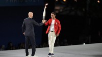 Ada legenda tenis Rafael Nadal yang menerima operan api obor Olimpiade 2024 dari tangan Zidane. Foto: AP/Natacha Pisarenko