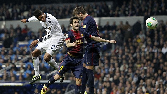 MADRID, SPAIN - JANUARY 30:  Raphael Varane of Real Madrid heads the ball to score past Cesc Fabregas (C) and Gerard Pique of Barcelona during the Copa del Rey Semi-Final first leg match between Real Madrid CF and FC Barcelona at Estadio Santiago Bernabeu on January 30, 2013 in Madrid, Spain.  (Photo by Angel Martinez/Real Madrid via Getty Images)