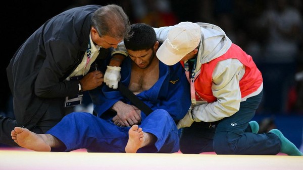 Tajikistans Nurali Emomali receives medical treatment during the judo mens -66kg quarter-final bout of the Paris 2024 Olympic Games at the Champ-de-Mars Arena, in Paris on July 28, 2024. (Photo by Luis ROBAYO / AFP)