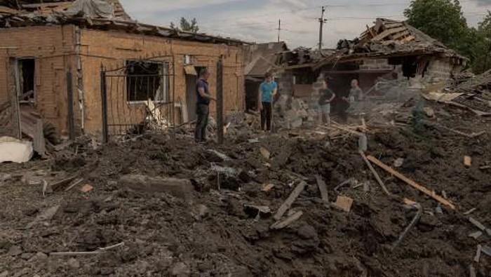 Residents clean debris next to heavily damaged houses following shelling in Pokrovsk,eastern Donetsk region, on June 24, 2024, amid the Russian invasion of Ukraine. Russian strikes on the eastern Ukrainian town of Pokrovsk killed four people and wounded dozens more on June 24, 2024 the governor of the Donetsk region said. (Photo by Roman PILIPEY / AFP)