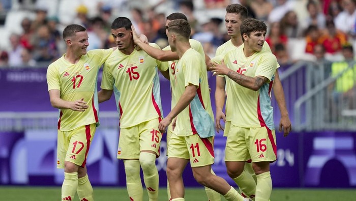 Spains Miguel Gutierrez (15) is congratulated by his teammates after scoring his sides 3rd goal against Dominican Republic during the mens Group C soccer match at the Bordeaux stadium at the 2024 Summer Olympics, Saturday, July 27, 2024, in Bordeaux, France. (AP Photo/Moises Castillo)