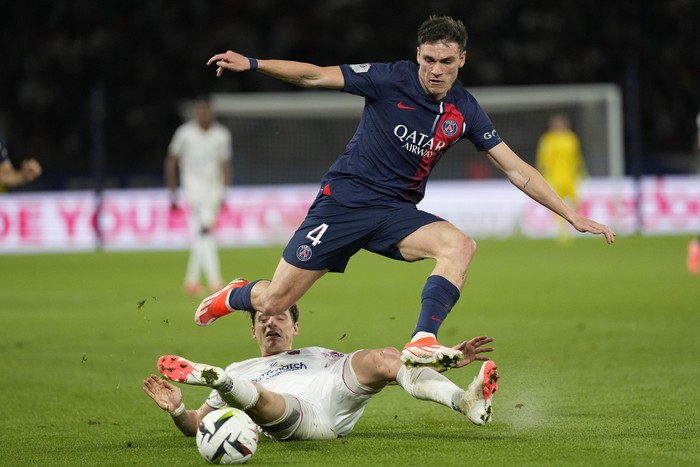 PSGs Manuel Ugarte, top, is challenged by Clermonts Yohann Magnin during the French League One soccer match between Paris Saint-Germain and Clermont at the Parc des Princes stadium in Paris, Saturday, April 6, 2024. (AP Photo/Lewis Joly)