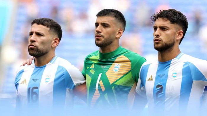 LYON, FRANCE - JULY 30: Nicolas Otamendi #16, Geronimo Rulli and Marco Di Cesare #2 of Team Argentina sing the national anthem prior to the Mens group B match between Ukraine and Argentina during the Olympic Games Paris 2024 at Stade de Lyon on July 30, 2024 in Lyon, France. (Photo by Claudio Villa/Getty Images)