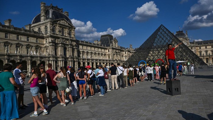 Pengunjung melintasi Piramida Louvre yang diarsiteki I M Pei di Museum Louvre, Paris, Prancis, Jumat (2/8/2024). Museum Louvre pernah dinobatkan dengan predikat “world’s astir visited creation museum” pada 2018 karena dikunjungi lebih dari sepuluh juta orang. ANTARA FOTO/Wahyu Putro A/foc.