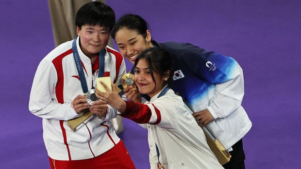 Paris 2024 Olympics - Badminton - Women's Singles Victory Ceremony - Porte de La Chapelle Arena, Paris, France - August 05, 2024. Gold medallist Se Young An of South Korea, silver medallist Bing Jiao He of China and bronze medallist Gregoria Mariska Tunjung of Indonesia take a selfie during the ceremony. REUTERS/Hamad I Mohammed