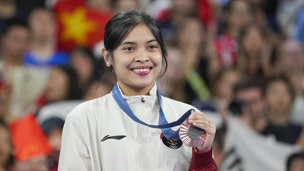 Indonesia's Gregoria Mariska Tunjung celebrates on the podium after wining the bronze medal at the badminton women singles at the 2024 Summer Olympics, Monday, Aug. 5, 2024, in Paris, France. (AP Photo/Kin Cheung)