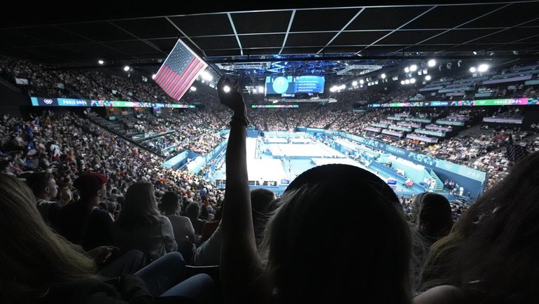 Para penggemar menyemangati para atlet selama sesi kedua selama babak kualifikasi senam artistik putra di Olimpiade Musim Panas 2024. AP/Charlie Riedel