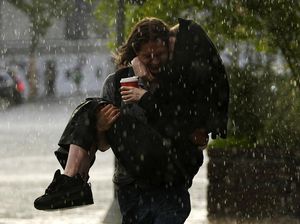 Potret Warga Menerobos Hujan Deras di Moskow