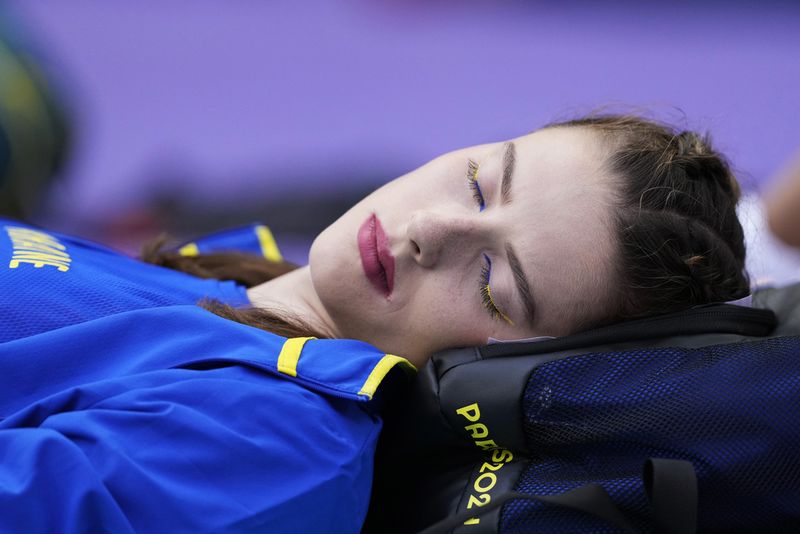 Yaroslava Mahuchikh, of Ukraine, rests before starting in the women's high jump qualification at the 2024 Summer Olympics, Friday, Aug. 2, 2024, in Saint-Denis, France. (AP Photo/Bernat Armangue)
