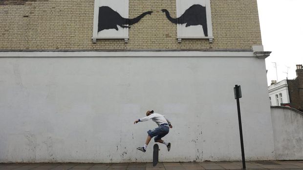A person skateboards by a new artwork by the British artist Banksy, in Fulham, London, Britain, August 6, 2024. REUTERS/Mina Kim