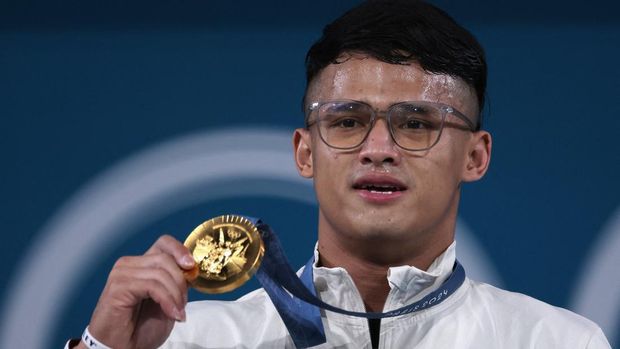 Paris 2024 Olympics - Weightlifting - Men's 73kg Victory Ceremony - South Paris Arena 6, Paris, France - August 08, 2024. Gold medallist Rizki Juniansyah of Indonesia poses with his medal. REUTERS/Amanda Perobelli
