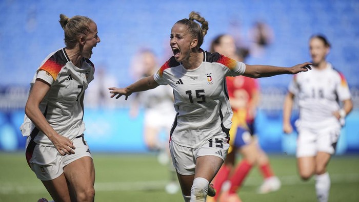 Germanys Giulia Gwinn, center, celebrates with Germanys Schueller Lea after scoring during the womens bronze medal soccer match between Spain and Germany, at the Lyon stadium, during the 2024 Summer Olympics, Friday, Aug. 9, 2024, in Decines, France. (AP Photo/Laurent Cipriani)