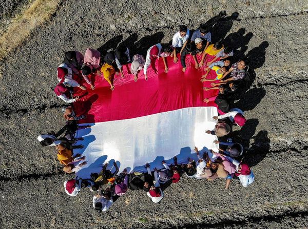 Aksi Anak-anak Bentangkan Bendera Merah Putih di Pelosok Nganjuk