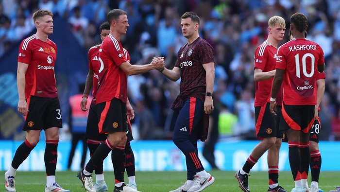 Soccer Football - Community Shield - Manchester United v Manchester City - Wembley Stadium, London, Britain - August 10, 2024 Manchester Uniteds Jonny Evans shakes hands with Tom Heaton after the match REUTERS/Toby Melville