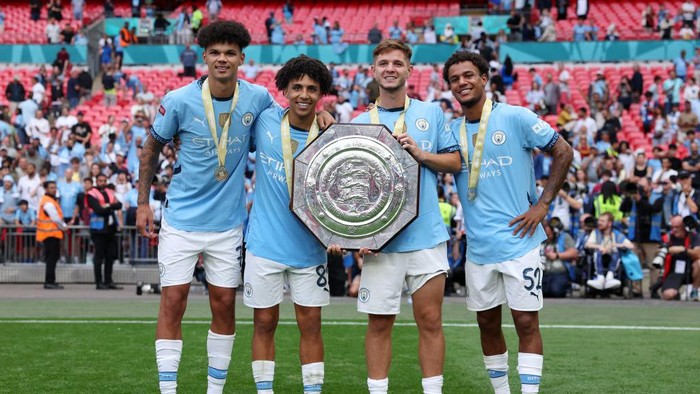 LONDON, ENGLAND - AUGUST 10: Nico OReilly, Rico Lewis, James McAtee, and Oscar Bobb of Manchester City celebrate with the trophy following the teams victory in the penalty shootout during the 2024 FA Community Shield match between Manchester United and Manchester City at Wembley Stadium on August 10, 2024 in London, England. (Photo by Eddie Keogh - The FA/The FA via Getty Images)