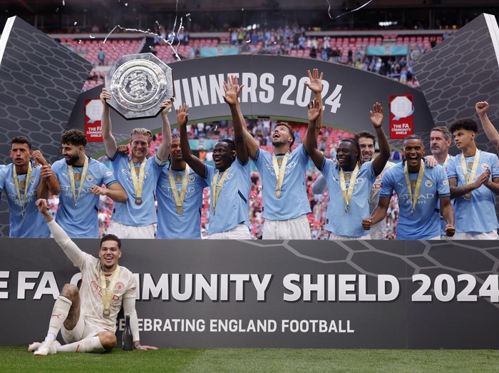 Soccer Football - Community Shield - Manchester United v Manchester City - Wembley Stadium, London, Britain - August 10, 2024 Manchester City's Kevin De Bruyne lifts the trophy as he celebrates with teammates after winning the Community Shield REUTERS/Andrew Couldridge