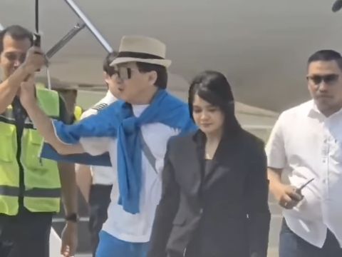 Jackie Chan dengan sopan menolak memakai payung saat tiba di Bandara Halim Perdana Kusuma.