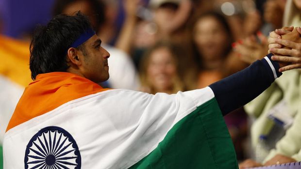 Paris 2024 Olympics - Athletics - Men's Javelin Throw Final - Stade de France, Saint-Denis, France - August 8, 2024. Neeraj Chopra of India celebrates with his national flag after winning silver REUTERS/Alina Smutko