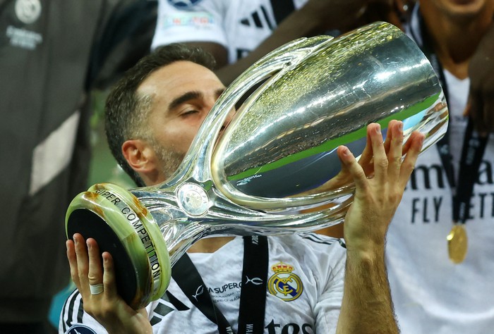 Soccer Football - Super Cup - Real Madrid v Atalanta - National Stadium, Warsaw, Poland - August 14, 2024 Real Madrids Dani Carvajal celebrates with the trophy after winning the Super Cup REUTERS/Kacper Pempel