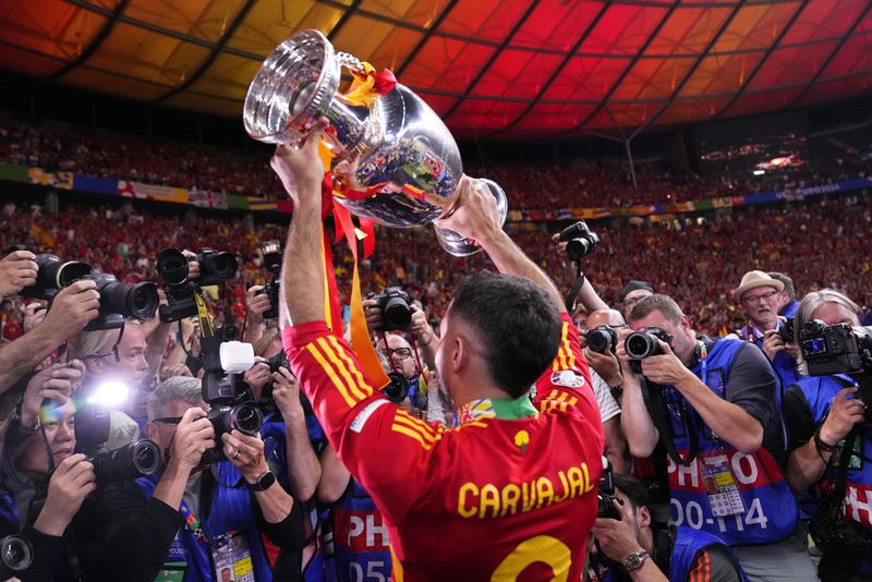 Spain's Dani Carvajal holds up the trophy to the fans after winning the final match between Spain and England at the Euro 2024 soccer tournament in Berlin, Germany, Sunday, July 14, 2024. Spain won 2-1. (AP Photo/Manu Fernandez)