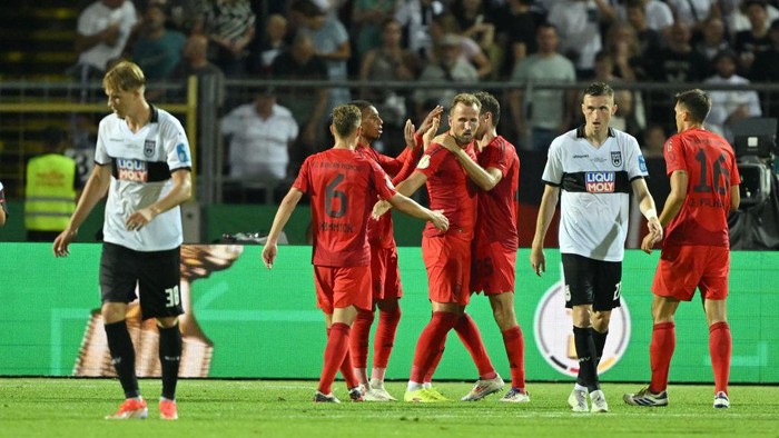 ULM, GERMANY - AUGUST 16: Harry Kane of FC Bayern Muenchen celebrates with team mates after scoring his teams fourth goal during the DFB-Pokal match between SSV Ulm 1846 and FC Bayern München at Donaustadion on August 16, 2024 in Ulm, Germany. (Photo by Sebastian Widmann/Getty Images)