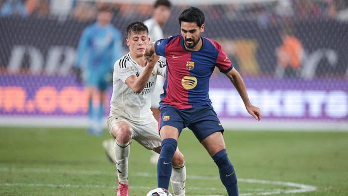 Aug 3, 2024; East Rutherford, NJ, USA; Barcelona midfielder Ilkay Gundogan (22) battles Real Madrid midfielder Arda Guler (15) for the ball during the second half of an international friendly at MetLife Stadium. Mandatory Credit: Vincent Carchietta-USA TODAY Sports