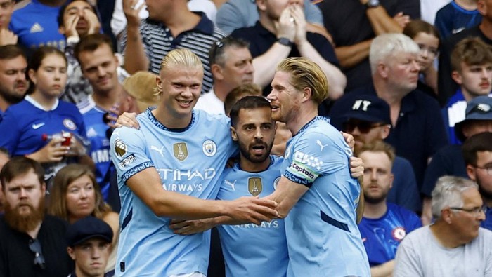Chelsea vs Manchester City Soccer Football - Premier League - Chelsea v Manchester City - Stamford Bridge, London, Britain - August 18, 2024 Manchester City's Erling Haaland celebrates scoring their first goal with Bernardo Silva and Kevin De Bruyne Action Images via Reuters/Peter Cziborra EDITORIAL USE ONLY. NO USE WITH UNAUTHORIZED AUDIO, VIDEO, DATA, FIXTURE LISTS, CLUB/LEAGUE LOGOS OR 'LIVE' SERVICES. ONLINE IN-MATCH USE LIMITED TO 120 IMAGES, NO VIDEO EMULATION. NO USE IN BETTING, GAMES OR SINGLE CLUB/LEAGUE/PLAYER PUBLICATIONS. PLEASE CONTACT YOUR ACCOUNT REPRESENTATIVE FOR FURTHER DETAILS..