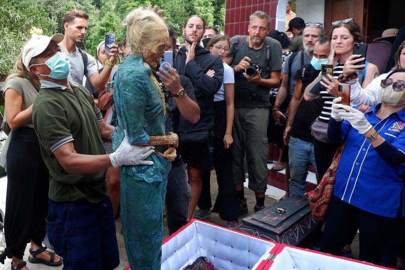 Warga mengangkat jenazah keluarganya saat ritual Ma'nene Suku Toraja di Lembang Maiting, Kecamatan Rindingallo, Kabupaten Toraja Utara, Sulawesi Selatan, Selasa (20/8/2024). Ritual Ma'nene atau pergantian pakaian jenazah tersebut telah dilakukan turun temurun oleh masyarakat Suku Toraja dan saat ini Pemda setempat mempromosikan budaya itu untuk menarik kunjungan wisatawan. ANTARA FOTO/Sakti Karuru/nym.