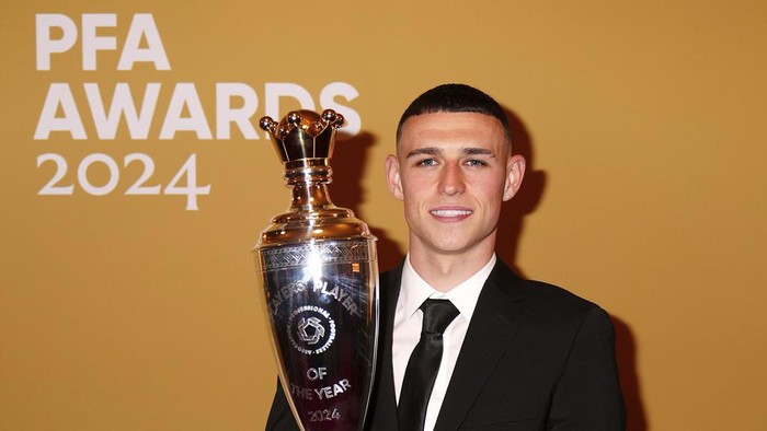 Potret Phil Foden Sabet Gelar Pemain Terbaik PFA 2023/2024 Phil Foden poses after winning the PFA Players' Player of the Year award during the 2024 PFA Awards at the Opera House Manchester, England, Tuesday Aug. 20, 2024. (Peter Byrne/PA via AP)