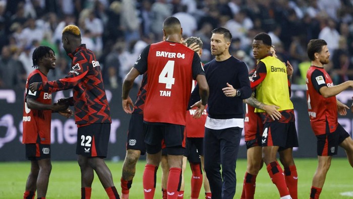 Soccer Football - Bundesliga - Borussia Moenchengladbach v Bayer Leverkusen - Borussia-Park, Moenchengladbach, Germany - August 23, 2024 Bayer Leverkusen coach Xabi Alonso with Jonathan Tah celebrate after the match REUTERS/Wolfgang Rattay DFL REGULATIONS PROHIBIT ANY USE OF PHOTOGRAPHS AS IMAGE SEQUENCES AND/OR QUASI-VIDEO.