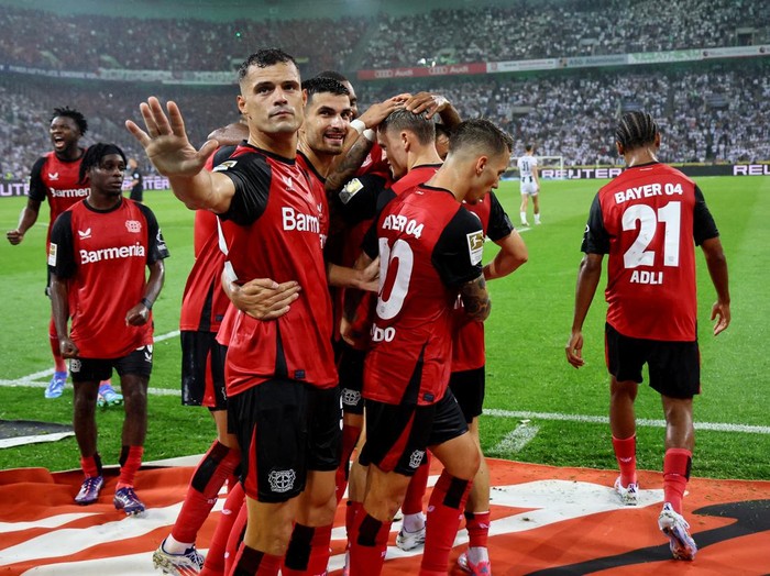 Soccer Football - Bundesliga - Borussia Moenchengladbach v Bayer Leverkusen - Borussia-Park, Moenchengladbach, Germany - August 23, 2024 Bayer Leverkusen's Florian Wirtz celebrates scoring their third goal with Granit Xhaka REUTERS/Wolfgang Rattay DFL REGULATIONS PROHIBIT ANY USE OF PHOTOGRAPHS AS IMAGE SEQUENCES AND/OR QUASI-VIDEO.