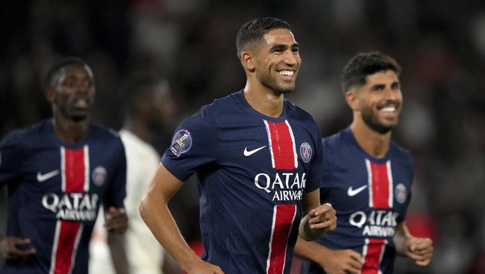 PSGs Achraf Hakimi smiles after scoring his sides fourth goal during the French League 1 soccer match between Paris Saint-Germain and Montpellier at the Parc des Princes in Paris, Friday, Aug. 23, 2024. (AP Photo/Thibault Camus)