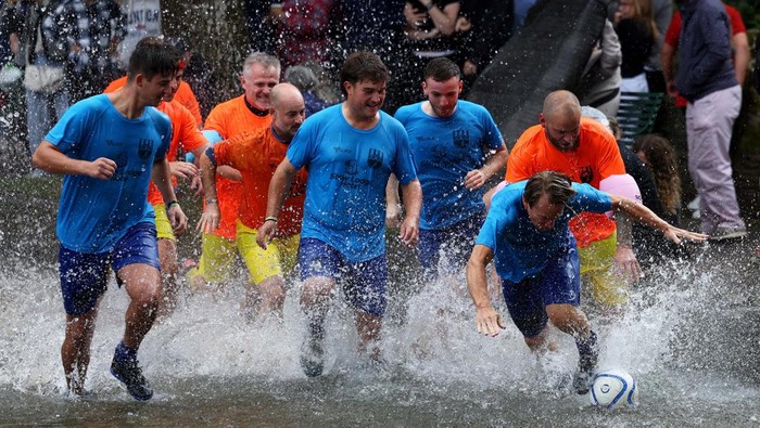 Serunya Pertandingan Bola di Sungai Windrush A player celebrates scoring during the annual football match in the River Windrush in Bourton-on-the-Water, Gloucestershire, Britain, August 26, 2024. REUTERS/Lee Smith