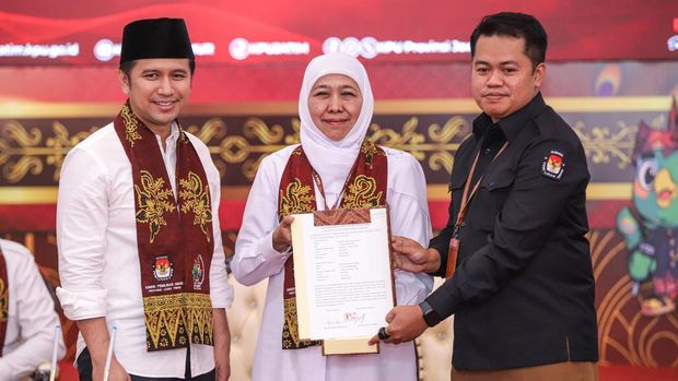 Ketua KPU Jatim Aang Kunaifi (kanan) menerima surat pernyataan visi, misi, dan program bakal calon Gubernur dan Wakil Gubernur Jawa Timur Khofifah Indar Parawansa (tengah) dan Emil Elestianto Dardak (kiri) saat pendaftaran di Kantor KPU Provinsi Jawa Timur, Surabaya, Jawa Timur, Rabu (28/8/2024). Khofifah Indar Parawansa dan Emil Elestianto Dardak resmi mendaftarkan diri sebagai peserta Pilgub Jatim 2024 dengan dukungan 15 partai yakni Gerindra, Golkar, Demokrat, NasDem,  Perindo, PAN, PKS, PPP, PSI, PKN, PBB, Partai Gelora, Partai Buruh, Partai Garuda, dan Partai Prima. ANTARA FOTO/Rizal Hanafi