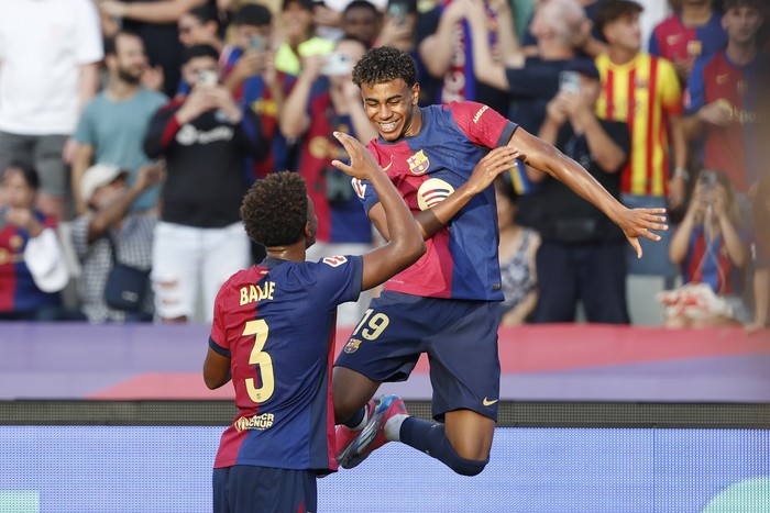 Barcelonas Lamine Yamal, right, celebrates after scoring the opening goal with Alejandro Balde during the Spanish La Liga soccer match between FC Barcelona and Athletic Bilbao at the Olympic stadium in Barcelona, Spain, Saturday, Aug. 24, 2024. (AP Photo/Joan Monfort)