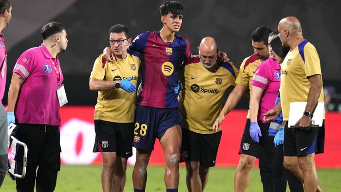 Barcelonas Marc Bernal gets treatment after an injury during the Spanish La Liga soccer match between Rayo Vallecano and Barcelona at the Vallecas stadium in Madrid, Spain, Tuesday, Aug. 27, 2024. (AP Photo/Manu Fernandez)