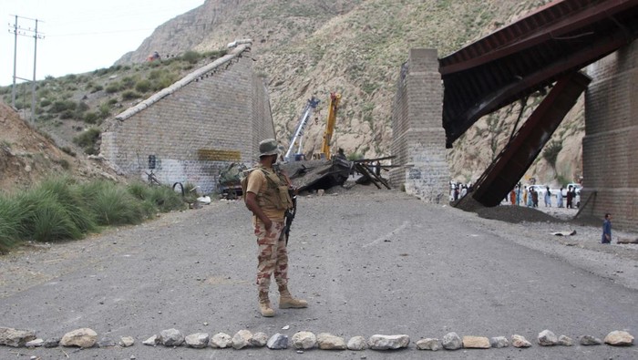Militer Pakistan Buru Militan yang Tewaskan Puluhan Orang di Balochistan A paramilitary soldier stands on a road, as restoration works go on at damaged railway tracks, a day after separatist militants conducted deadly attacks, in Bolan district of Pakistans restive province of Balochistan, Pakistan, August 27, 2024. REUTERS/Naseer Ahmed