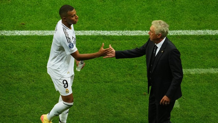 Soccer Football - Super Cup - Real Madrid v Atalanta - National Stadium, Warsaw, Poland - August 14, 2024 Real Madrids Kylian Mbappe shakes hands with coach Carlo Ancelotti after being substituted REUTERS/Aleksandra Szmigiel