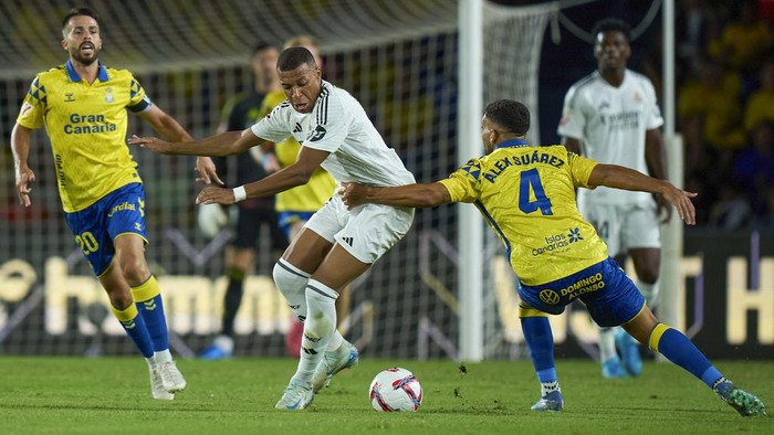 Real Madrids Kylian Mbappe, center, is challenged by Las Palmas Alex Suarez, right, during the Spanish La Liga soccer match between Las Palmas and Real Madrid at the Gran Canaria stadium in Las Palmas, Spain’s Canary Islands, Thursday, Aug. 29, 2024. (AP Photo/Gabriel Jimenez)