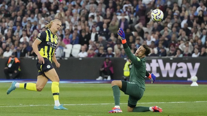 Manchester Citys Erling Haaland, left, scores his sides third goal during the English Premier League soccer match between West Ham United and Manchester City at the London Stadium in London, England, Saturday, Aug. 31, 2024. (AP Photo/Frank Augstein)