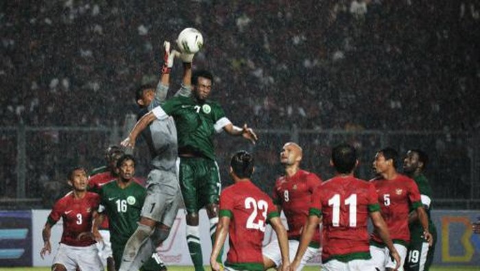 In this photo taken on March 23, 2013 Indonesian goal keeper Kurnia Mega (#1) tries to catch the ball during a match against Saudi Arabia at Bung Karno stadium in Jakarta. Following a bitter dispute between Indonesias football leagues, two rival football federations agreed on March 17, 2013 to unite three days before a deadline set by world governing body FIFA giving fresh hope on the future of the game in Indonesia.  Football in Southeast Asias biggest nation has been mired in cvontroversy for the past two years, with the Indonesian Football Association (PSSI) and the rival Indonesian Soccer Rescue Committee (KPSI) angering FIFA by running separate leagues and ignoring several deadlines to unite. AFP PHOTO / Bay ISMOYO (Photo by BAY ISMOYO / AFP)