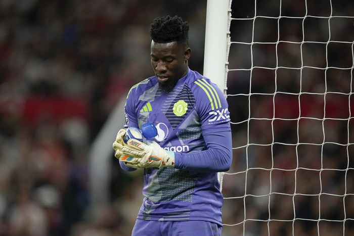 Manchester Uniteds goalkeeper Andre Onana puts vaseline on his gloves during the English Premier League soccer match between Manchester United and Fulham at Old Trafford, Friday, Aug. 16, 2024, in Manchester, England. (AP Photo/Dave Thompson)