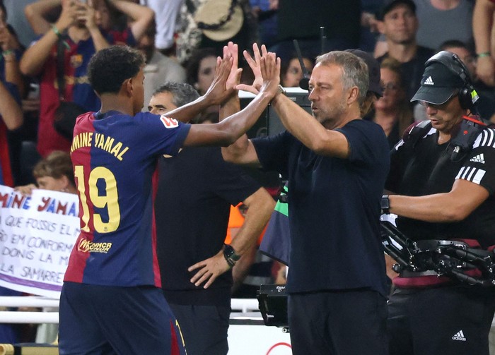 Soccer Football - LaLiga - FC Barcelona v Athletic Bilbao - Estadi Olimpic Lluis Companys, Barcelona, Spain - August 24, 2024 FC Barcelonas Lamine Yamal with coach Hansi Flick after being substituted REUTERS/Nacho Doce